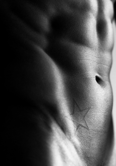 Kenny Braasch abs and star tattoo close-up in black and white.