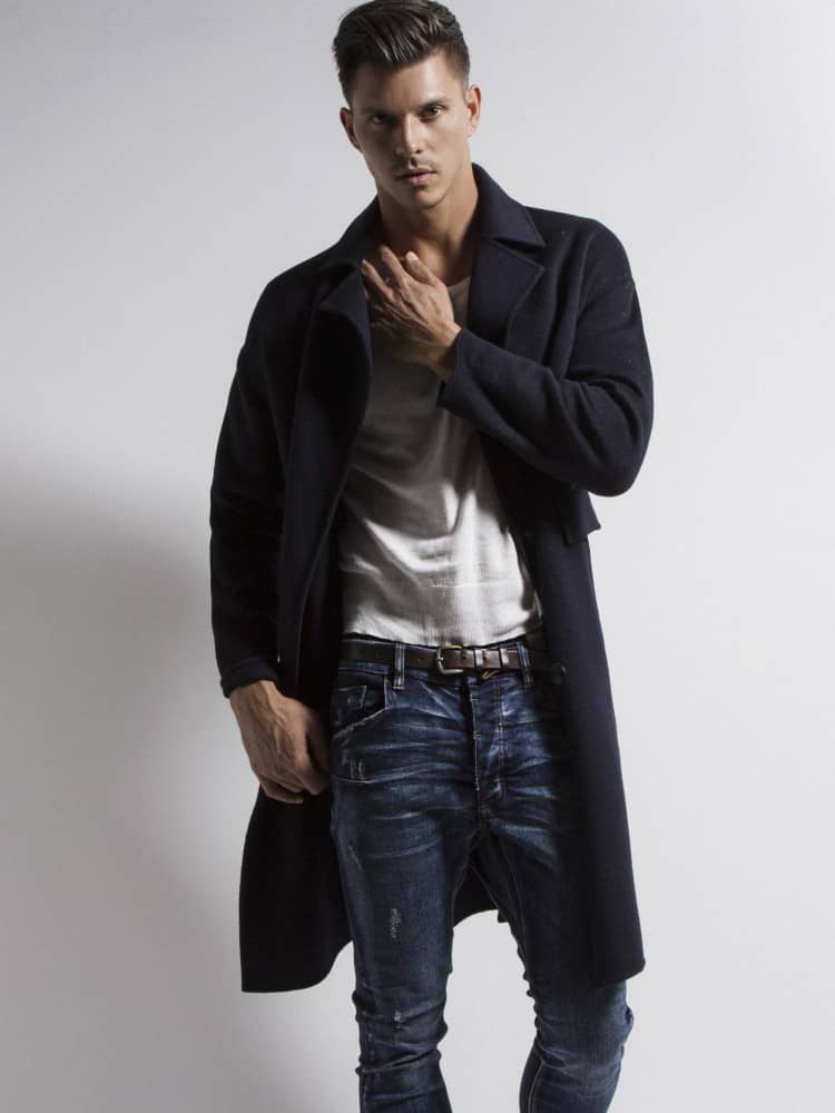 Kenny Braasch modeling navy blue peacoat, white shirt, and blue jeans.