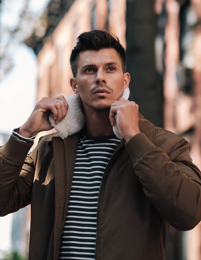 Kenny Braasch modeling a brown shearling coat and striped shirt.