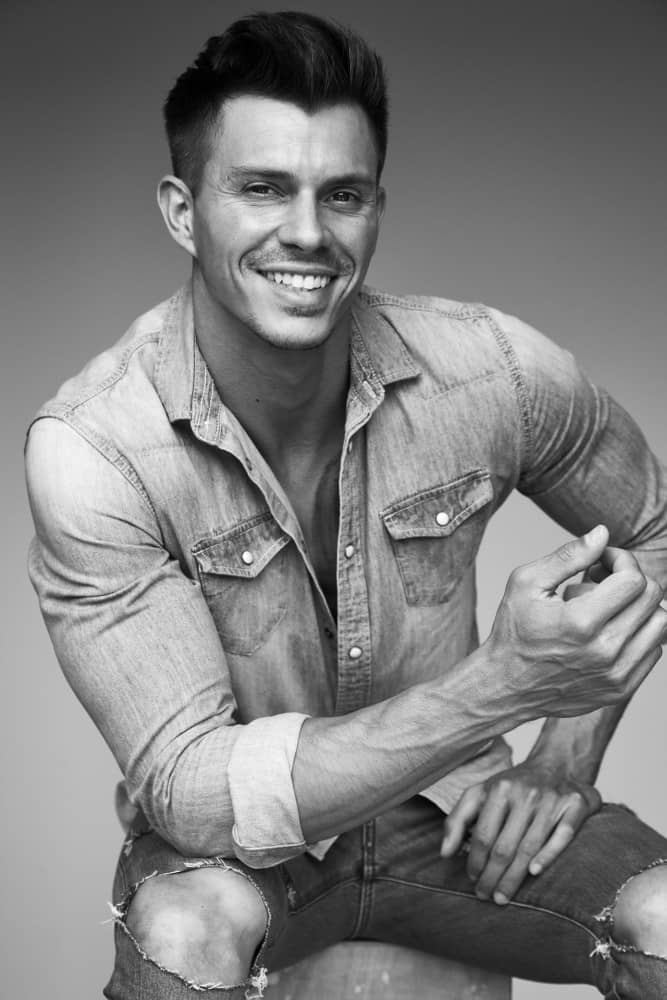 Kenny Braasch modeling an open jean shirt and jeans in black and white.